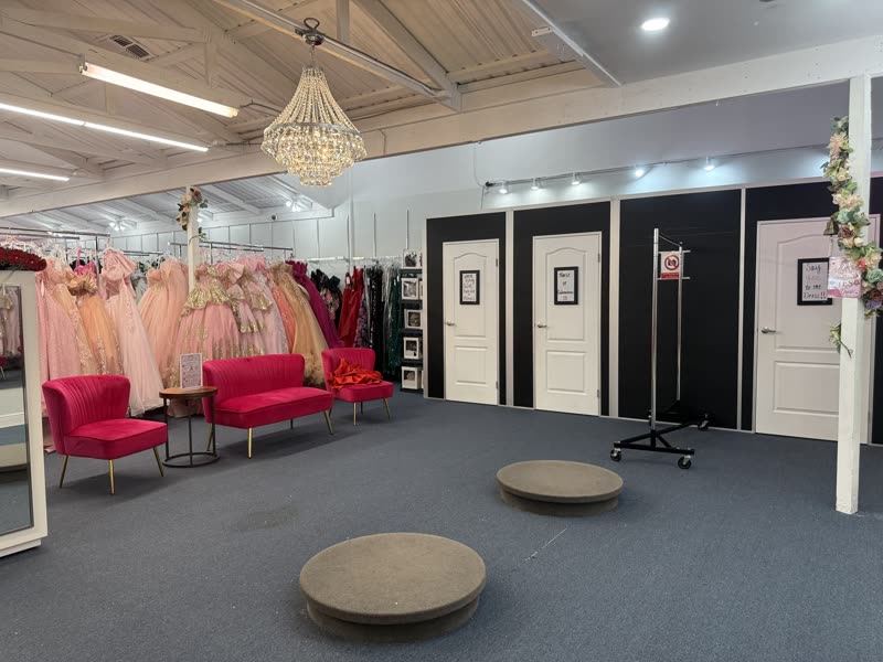 Private fitting lounge with chandelier, hot pink sofas and dressing rooms at House of Quinceañeras